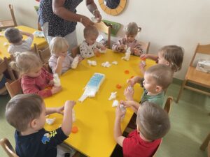 Dzieci wykonują bałwanki z butelek.