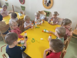 Dzieci wykonują bałwanki z butelek.
