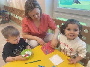 Dzieci robią laurki na Dzień babci i dziadka.