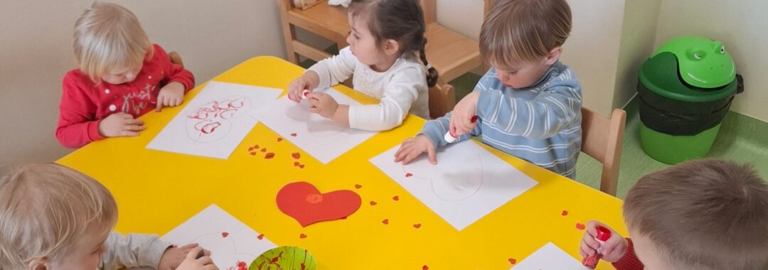 Dzieci odbijają i przyklejają serduszka