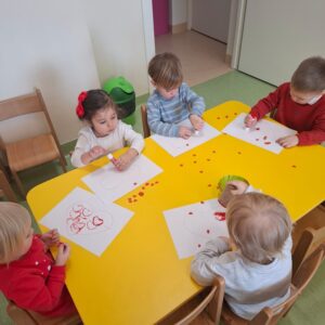Dzieci odbijają i przyklejają serduszka