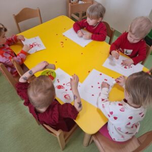 Dzieci odbijają i przyklejają serduszka