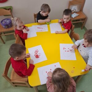 Dzieci odbijają i przyklejają serduszka