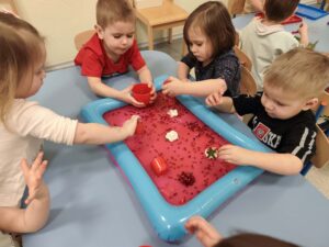 Dzieci bawią się masą sensoryczną z kisielu
