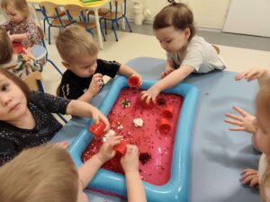 Dzieci bawią się masą sensoryczną z kisielu