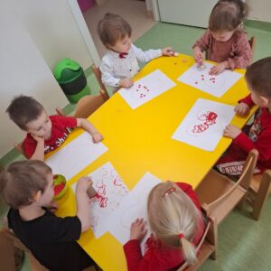Dzieci odbijają i przyklejają serduszka