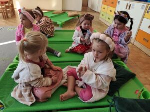 Dziewczynki siedzą na leżakach w szlafrokach