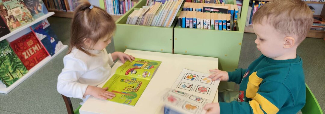 Dzieci oglądają książeczki w bibliotece