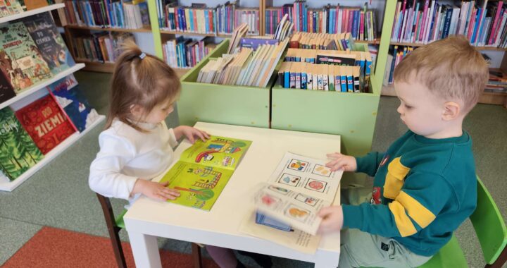 Dzieci oglądają książeczki w bibliotece