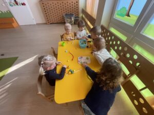 Dzieci nawlekają koraliki na drucik kreatywny