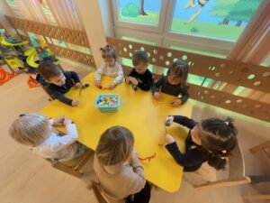 Dzieci nawlekają koraliki na drucik kreatywny