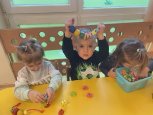 Dzieci nawlekają koraliki na drucik kreatywny