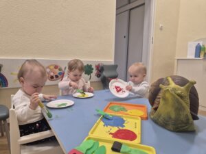 Dzieci malują farbami papierowy talerzyk, który będzie skorupą ślimaka.