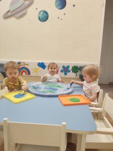 Dzieci malują farbami makietę Ziemi.