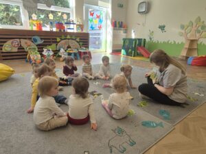 Ciocia czyta dzieciom książeczkę o tym, co możemy robić dla naszej planety, żeby żyło nam się lepiej.