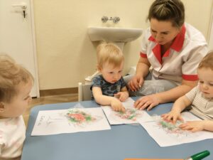 Dzieci malują folię farbą w wiosennych kolorach.