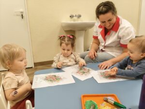 Dzieci odbijają farbę poprzez folię bąbelkową.