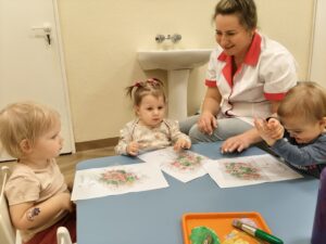 Dzieci odbijają farbę poprzez folię bąbelkową.