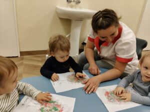 Dzieci odbijają farbę na folii bąbelkowej, a następnie odbijają farbę na szablonie drzewa.