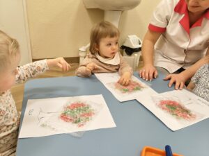 Dzieci odbijają farbę poprzez folię bąbelkową.
