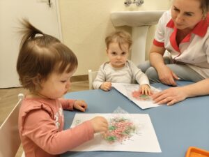 Dzieci odbijają farbę poprzez folię bąbelkową.