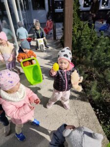 Dzieci szukają ukrytych kolorowych jajek w ogrodzie