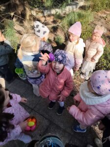 Dzieci szukają ukrytych kolorowych jajek w ogrodzie