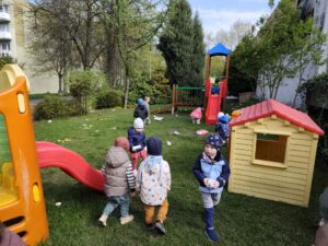 Dzieci na ogrodzie sprzątają śmieci i wkładają je do odpowiednich worków