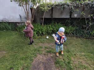 Dzieci na ogrodzie sprzątają śmieci i wkładają je do odpowiednich worków