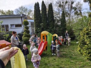 Dzieci na ogrodzie sprzątają śmieci i wkładają je do odpowiednich worków