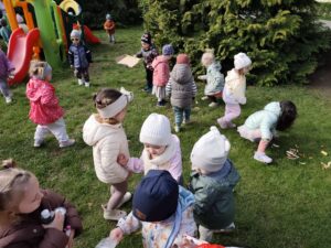 Dzieci na ogrodzie sprzątają śmieci i wkładają je do odpowiednich worków