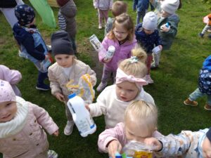 Dzieci na ogrodzie sprzątają śmieci i wkładają je do odpowiednich worków