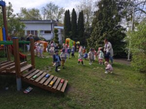 Dzieci na ogrodzie sprzątają śmieci i wkładają je do odpowiednich worków