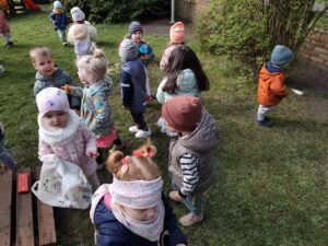 Dzieci na ogrodzie sprzątają śmieci i wkładają je do odpowiednich worków