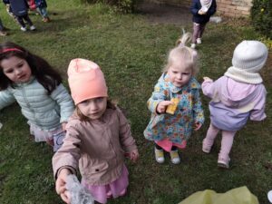 Dzieci na ogrodzie sprzątają śmieci i wkładają je do odpowiednich worków