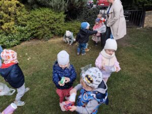 Dzieci na ogrodzie sprzątają śmieci i wkładają je do odpowiednich worków