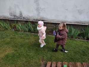 Dzieci na ogrodzie sprzątają śmieci i wkładają je do odpowiednich worków