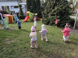 Dzieci na ogrodzie sprzątają śmieci i wkładają je do odpowiednich worków