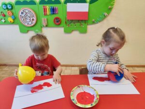 Dzieci malują flagę Polski za pomocą balona