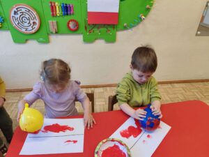 Dzieci malują flagę Polski za pomocą balona
