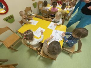 Dzieci wyklejają watą jajko i farbują za pomocą pipety
