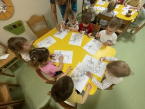 Dzieci wyklejają watą jajko i farbują za pomocą pipety
