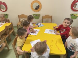 Dzieci wyklejają watą jajko i farbują za pomocą pipety