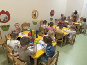 Dzieci wyklejają watą jajko i farbują za pomocą pipety