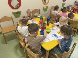 Dzieci wyklejają watą jajko i farbują za pomocą pipety