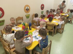 Dzieci wyklejają watą jajko i farbują za pomocą pipety