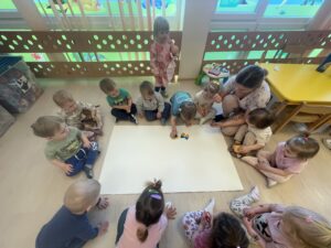 Dzieci tworzą motyle odbijając gąbkę pomalowaną farbą.