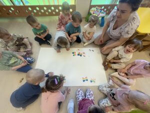 Dzieci tworzą motyle odbijając gąbkę pomalowaną farbą.