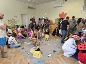 Dzieci pomagają zebrać rozrzucone Kropki Biedroneczki.