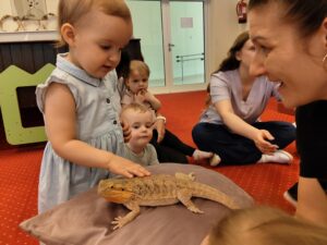 Dziewczynka głaszcze Agamę.